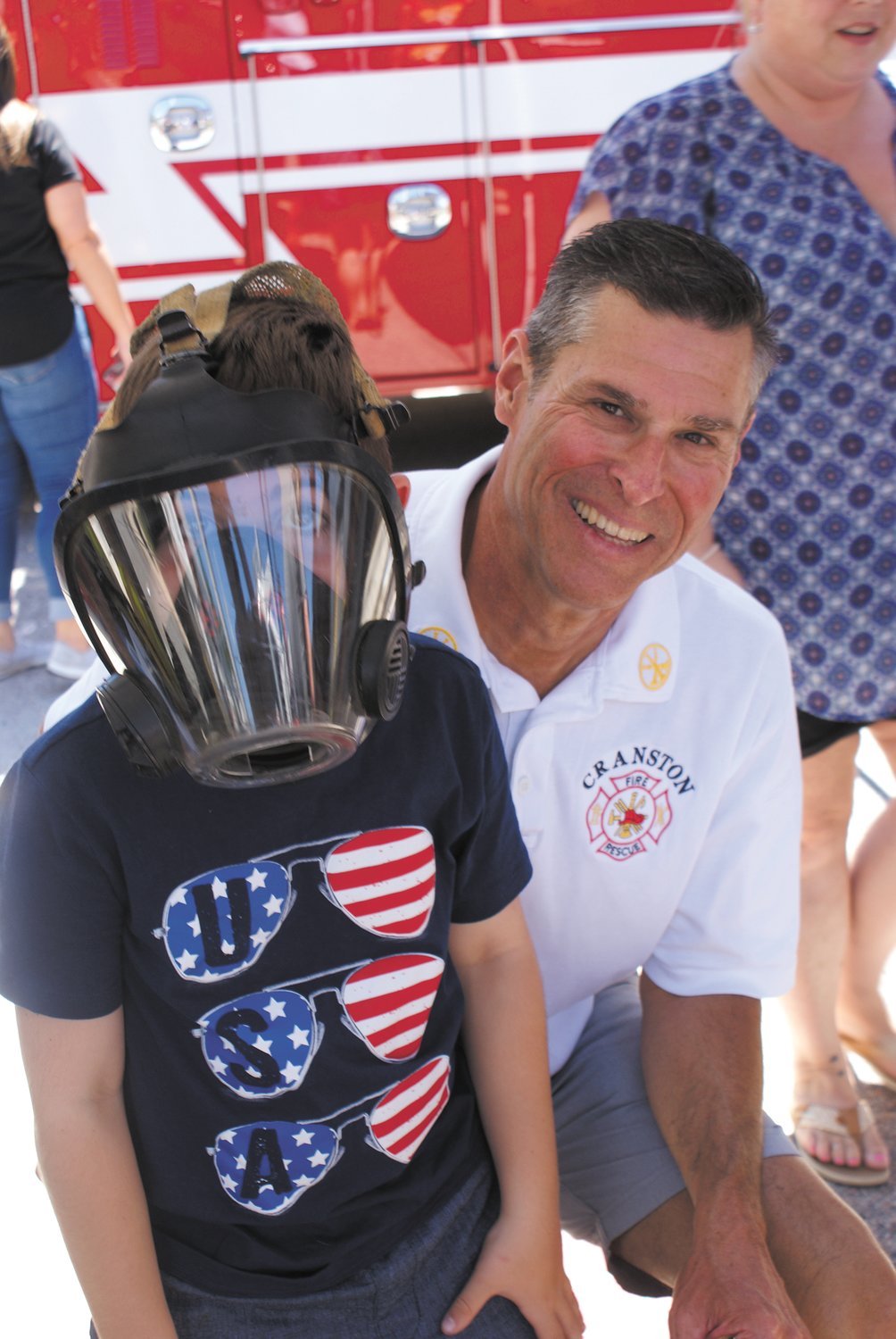 TESTING FIREFIGHTER GEAR: Seven-year-old Rocco Forte stood with Chief Jim Warren while trying on his mask.